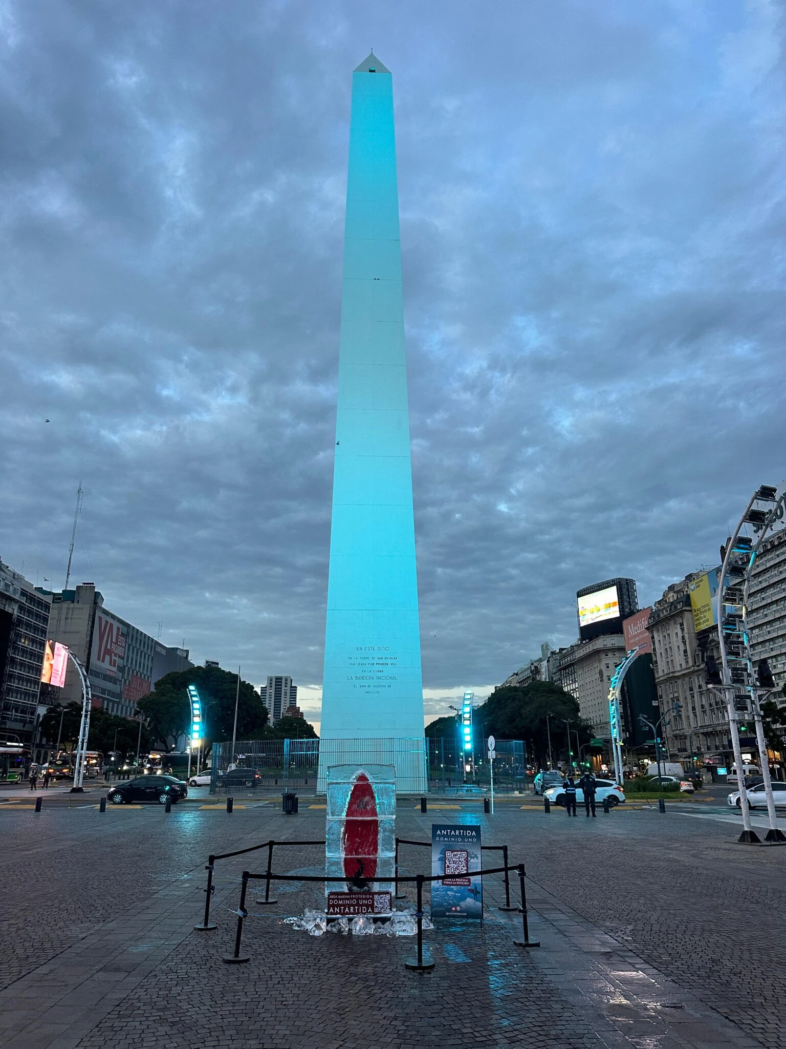 Instalación de Antártica - Dominio Uno frente al Obelisco con una tabla de surf congelada y señalización de la campaña.
