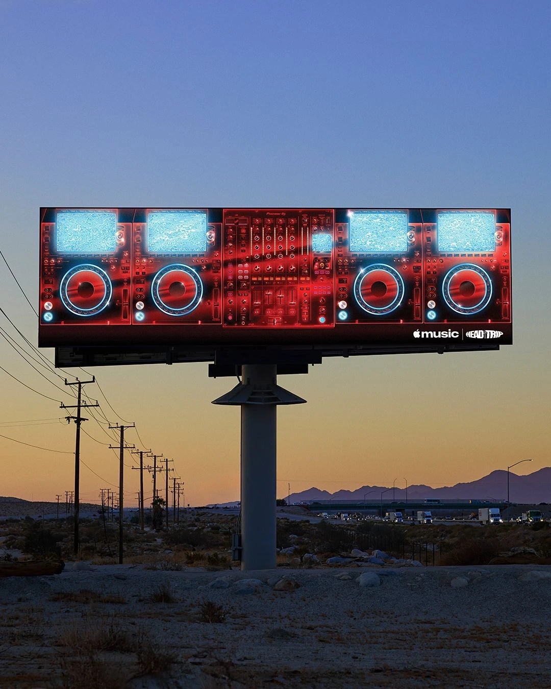 Espectacular de Apple Music x Head Trip Indio con una consola de DJ iluminada en rojo en medio del paisaje desértico.