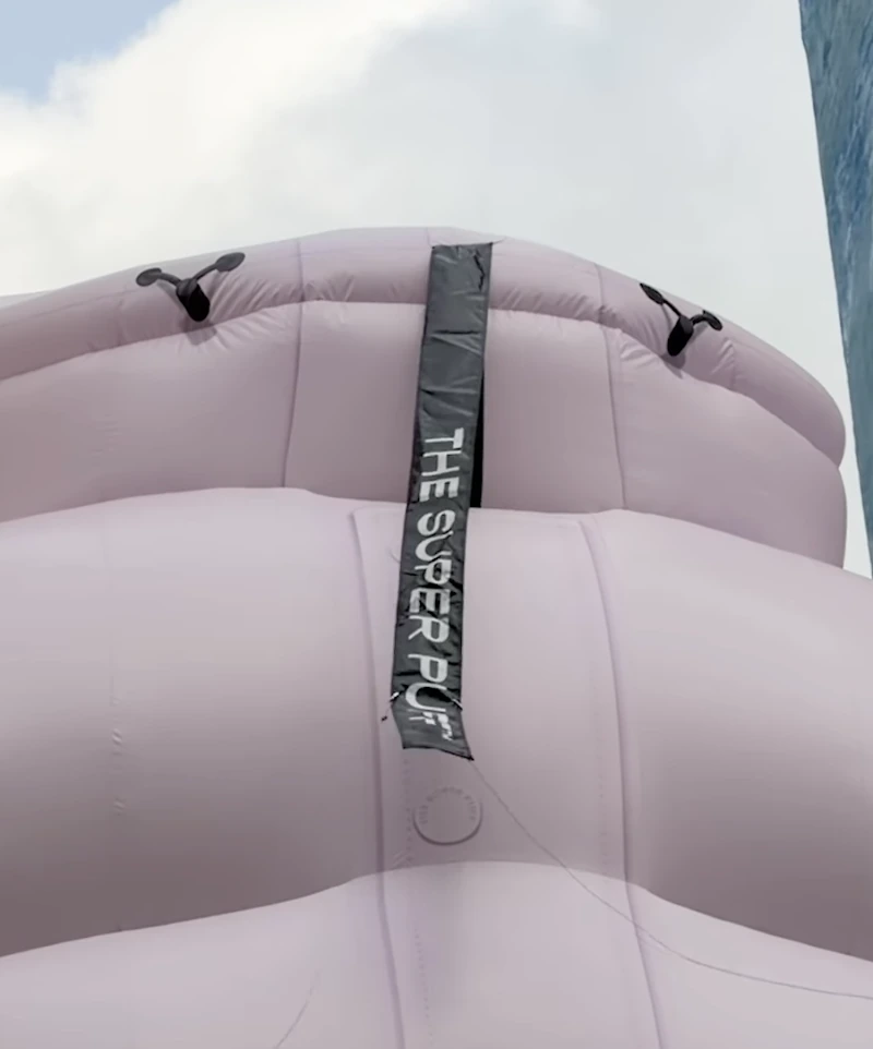 Detalle del cuello de la instalación inflable del Aritzia Super Puff con una cinta que dice The Super Puff.