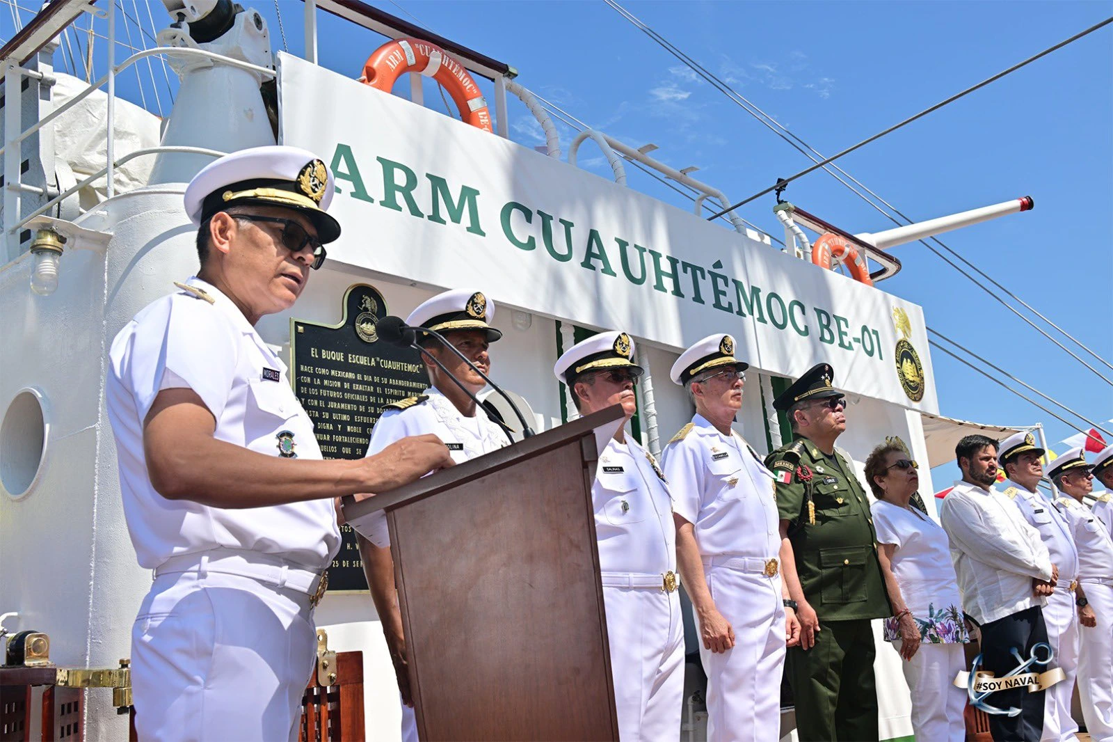 Ceremonia oficial a bordo del ARM Cuauhtémoc con personal naval y representantes frente al nombre de la embarcación.