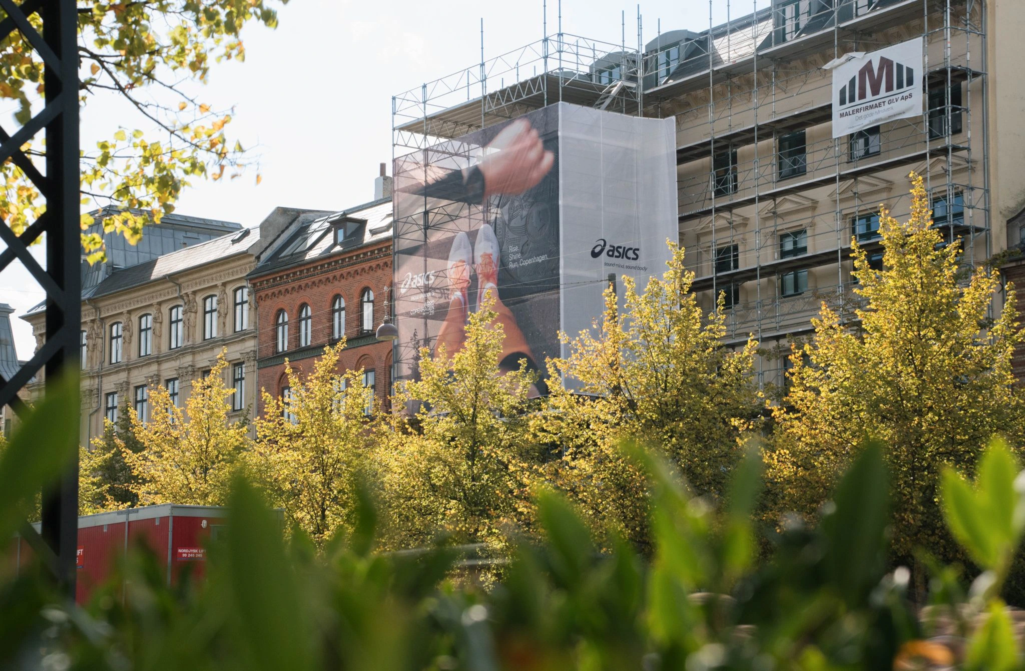 Gran formato de ASICS instalado sobre la fachada de un edificio en Copenhague con creatividad vinculada al running y al mensaje Sound Mind Sound Body.