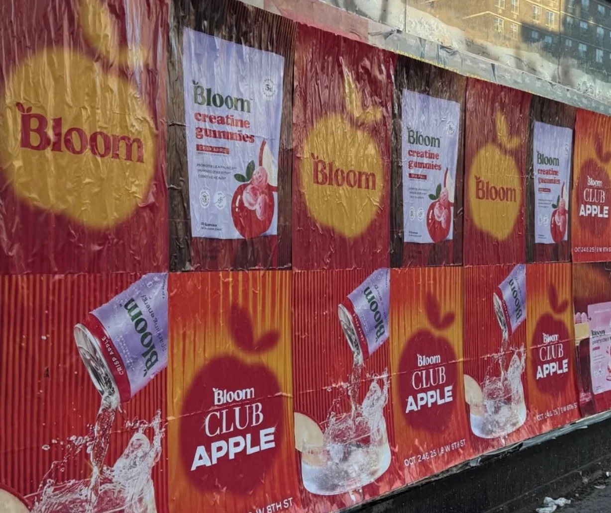 Campaña Bloom Club Apple en Nueva York con wildposting rojo y amarillo para Creatine Gummies sabor Crisp Apple.