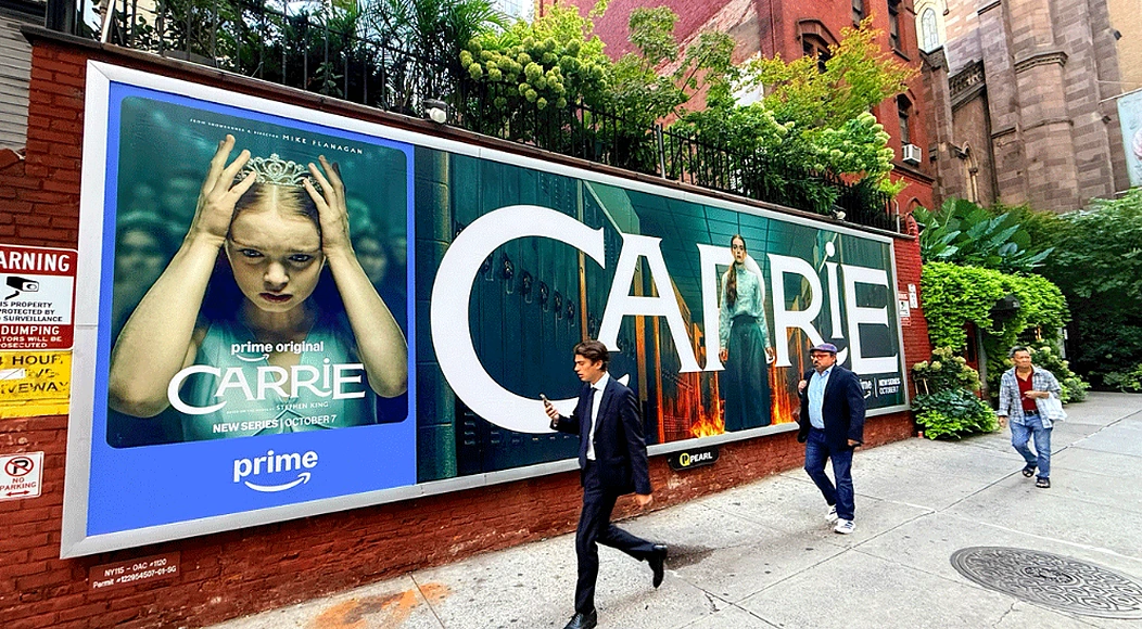 Billboard de Carrie de Prime Video a nivel de calle en Nueva York con el título CARRIE en gran formato y peatones caminando frente al anuncio.