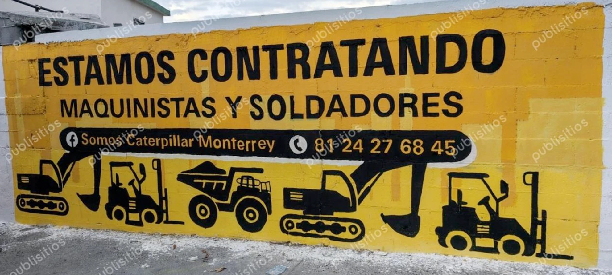 Pinta de barda de Caterpillar Monterrey con mensaje de contratación para maquinistas y soldadores e ilustraciones de maquinaria pesada.