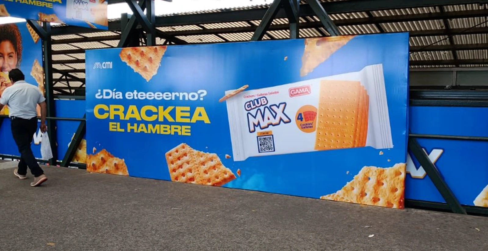 Paradero de Club Max en Guatemala con la campaña Crackea el Hambre, branding azul, paquete de galletas y el mensaje Naaaaada que llega el bus.