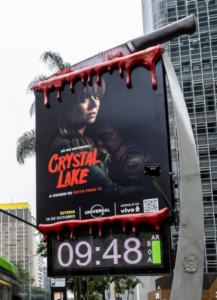 Billboard de Crystal Lake intervenido con un cuchillo gigante y sangre falsa que escurre por la parte superior e inferior de la estructura.