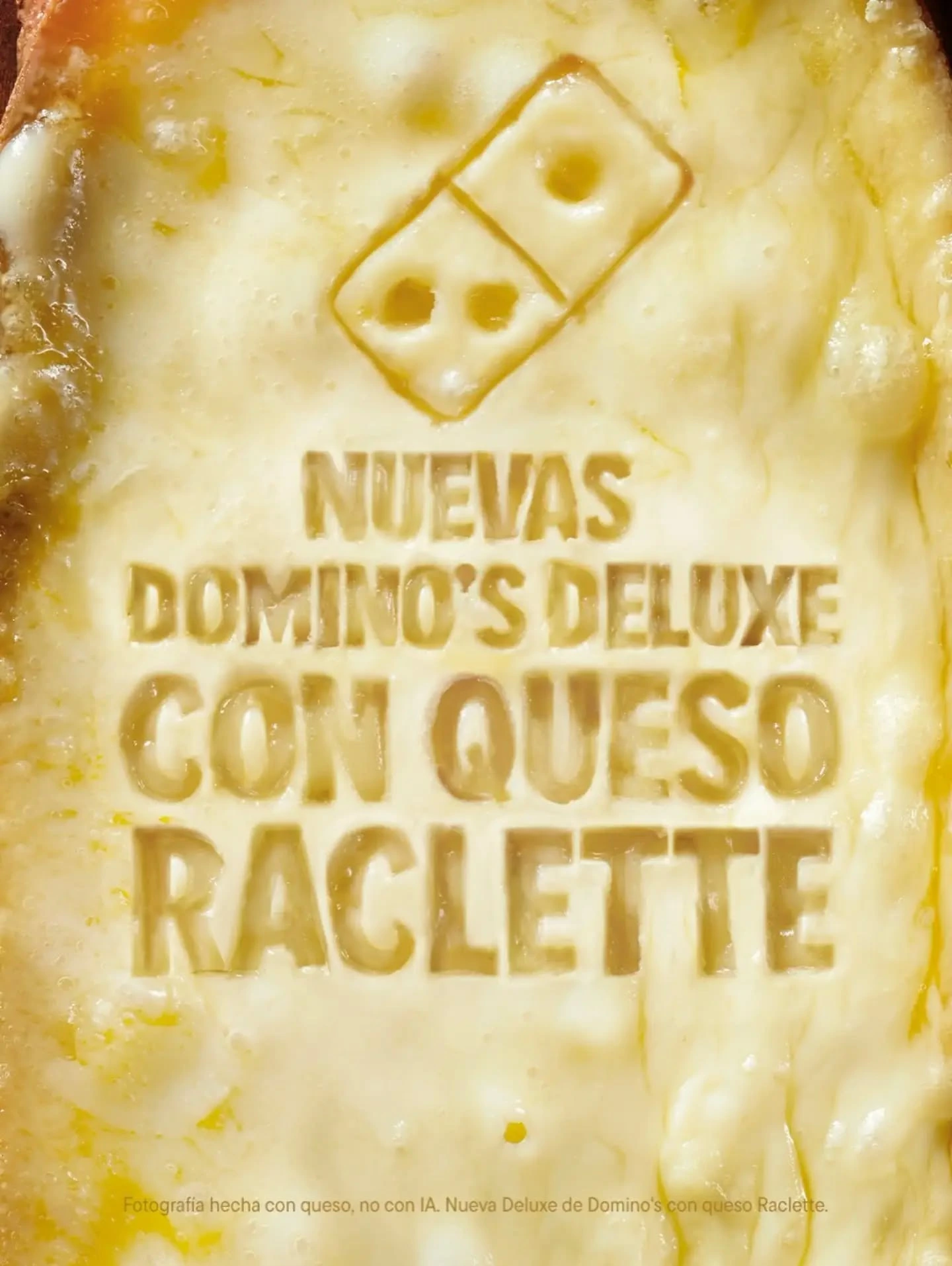 Creatividad de Domino’s Deluxe Raclette fotografiada sobre queso real.