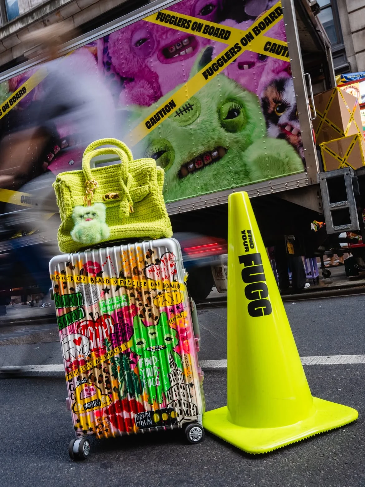 Activación de Fuggler durante Fashion Week en SoHo con un camión intervenido con personajes, un bolso verde neón, una maleta gráfica y un cono fluorescente.