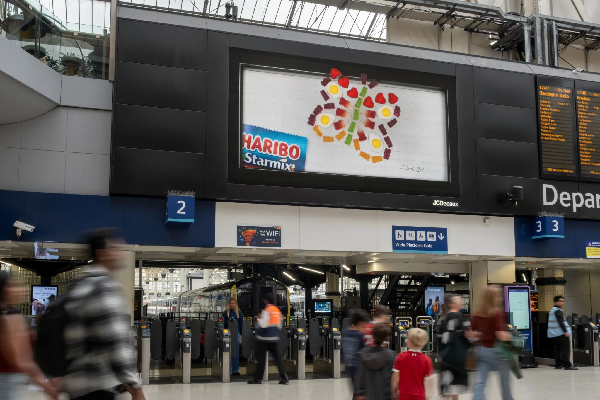 Publicidad de HARIBO Starmix en una estación de tren con una composición creada mediante gomitas Starmix.