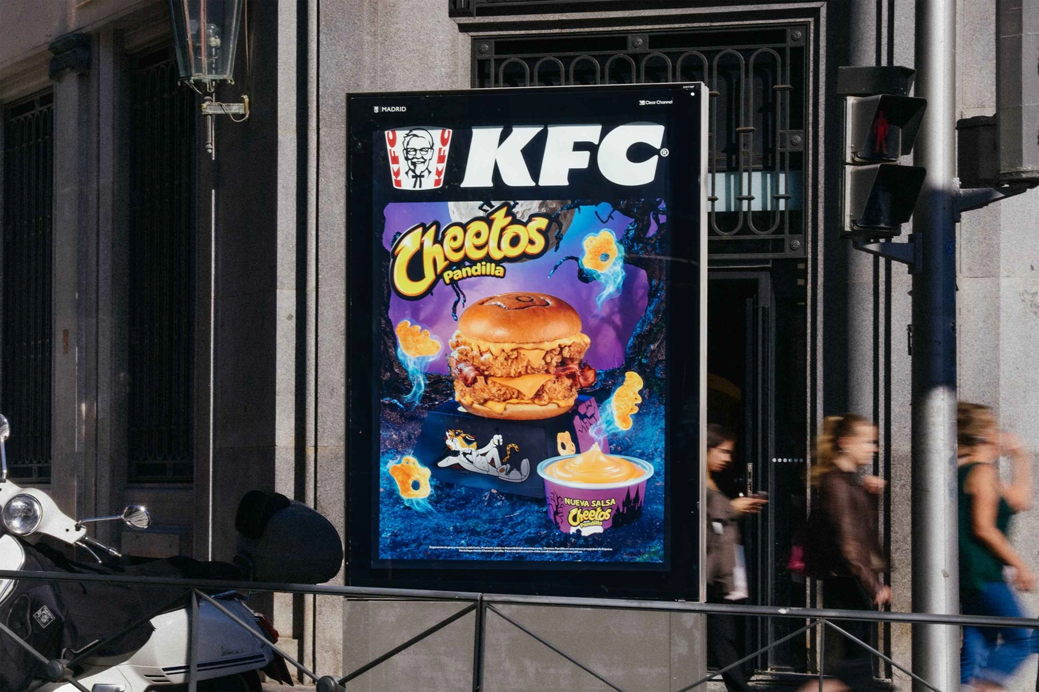 Mupi diurno de KFC x Cheetos Pandilla mostrando la burger, la salsa y los elementos gráficos de la colaboración en España.