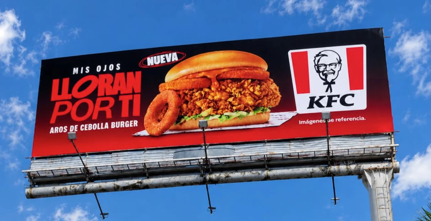 Espectacular diurno de KFC Colombia para la Aros de Cebolla Burger con fondo negro y rojo.