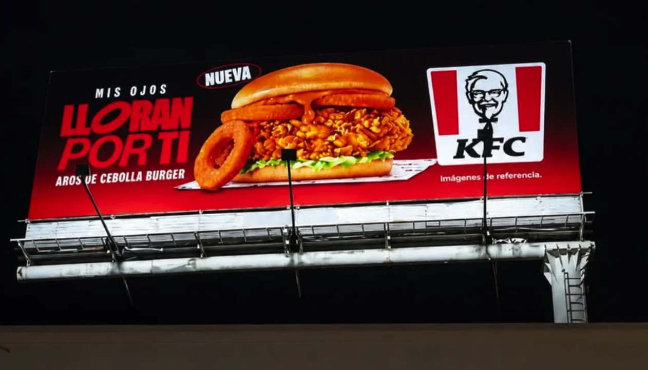 Espectacular nocturno de KFC Colombia promocionando la Aros de Cebolla Burger con el mensaje Mis ojos lloran por ti.