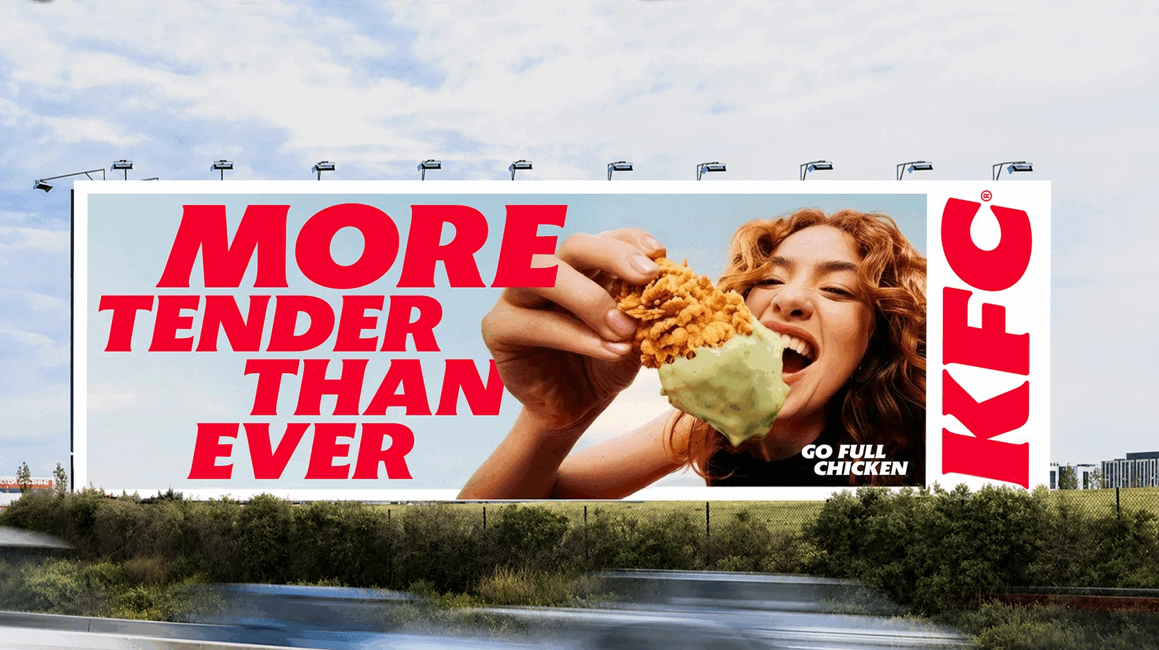 Billboard de KFC Australia con el mensaje More Tender Than Ever y una persona sosteniendo un Chicken Tender con dipping sauce.