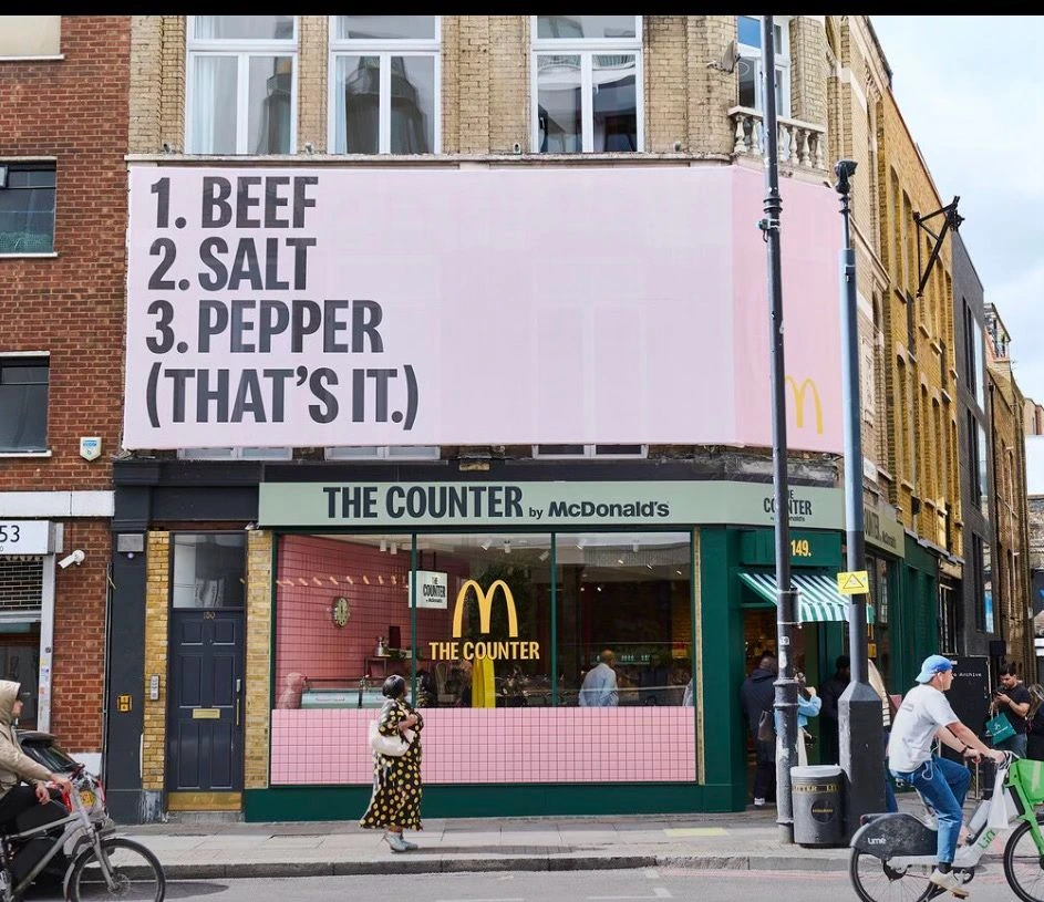 Fachada de The Counter by McDonald’s en Shoreditch con un gran anuncio exterior que dice 1. Beef 2. Salt 3. Pepper That's it.