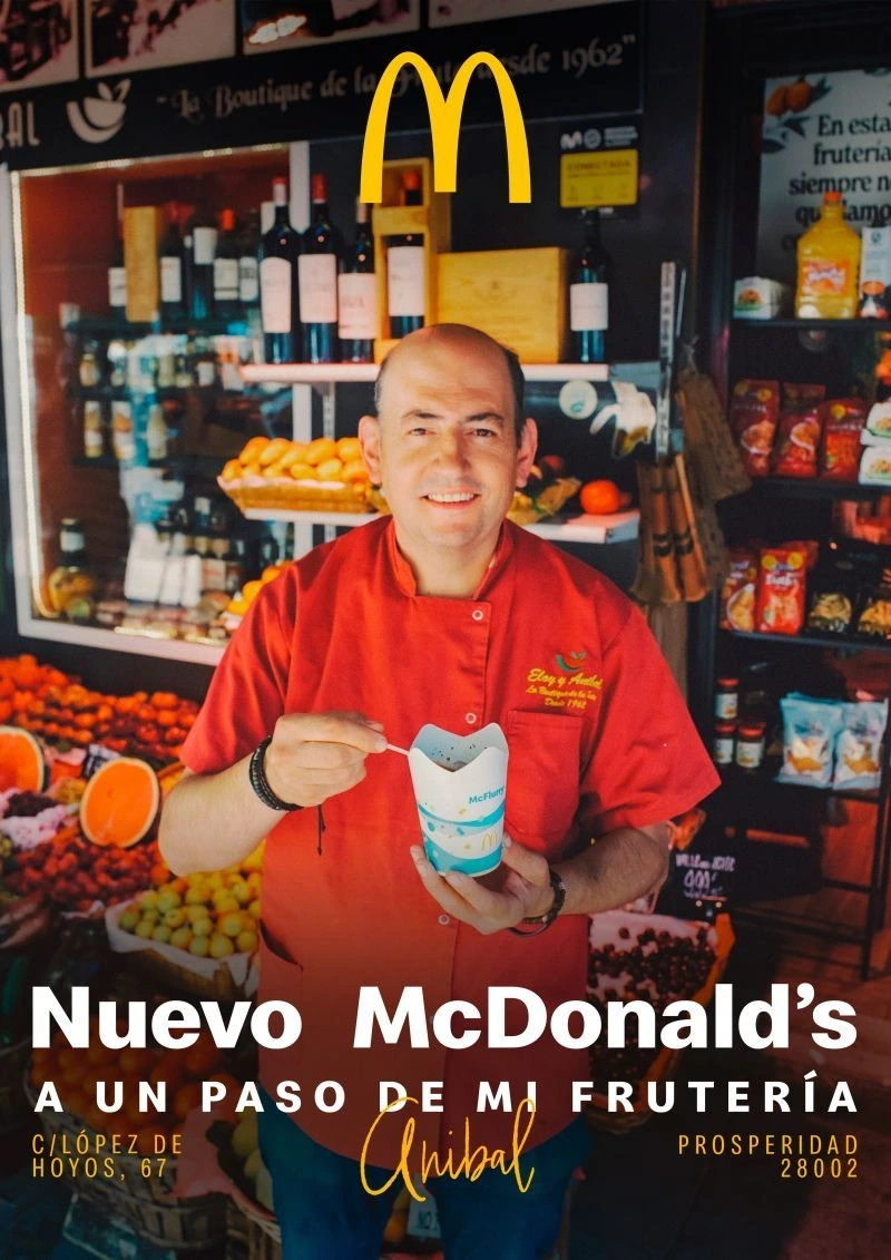 Pieza de la campaña Uno más del barrio con un frutero local sosteniendo un McFlurry y mensaje sobre la cercanía del nuevo McDonald's.