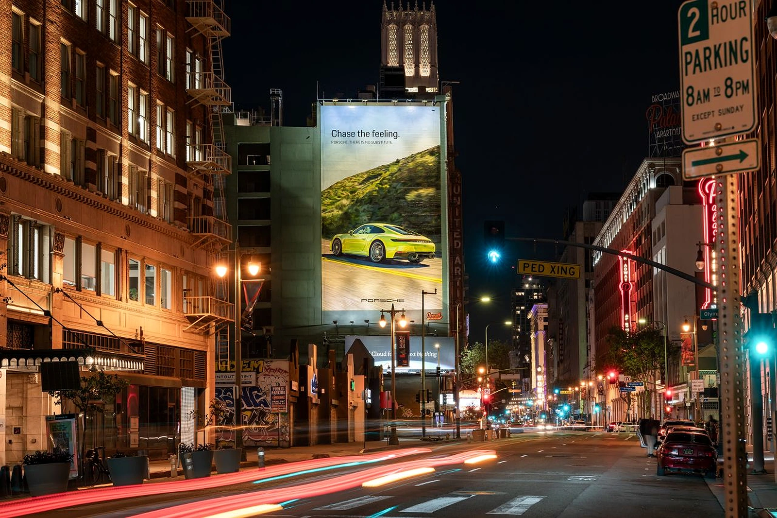 Mural de Porsche There Is No Substitute pintado a mano en una fachada urbana con un Porsche deportivo y el mensaje Chase the feeling.