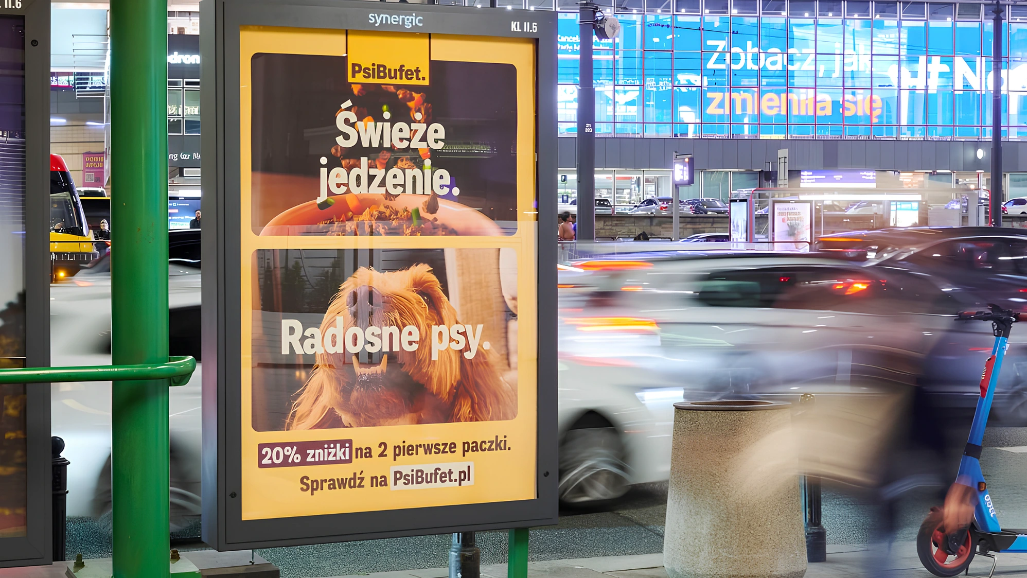 Panel CLP de PsiBufet en una zona urbana de Polonia con el mensaje comida fresca, perros felices y una oferta de 20% de descuento.