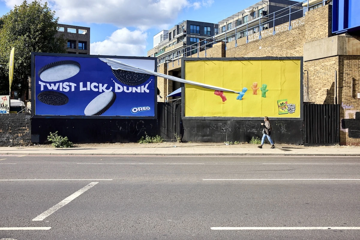 Vista amplia de dos billboards en calle con una ejecución de Sour Patch Kids interviniendo una pieza de Oreo.