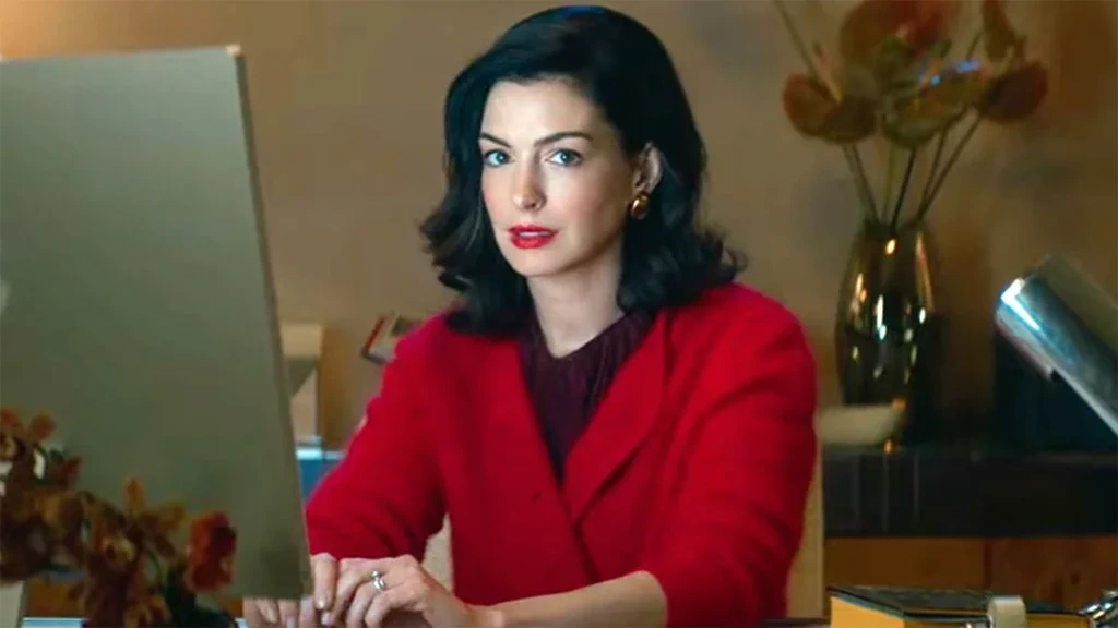 Escena promocional de Verity con una mujer vestida de rojo frente a una computadora dentro de un espacio interior.