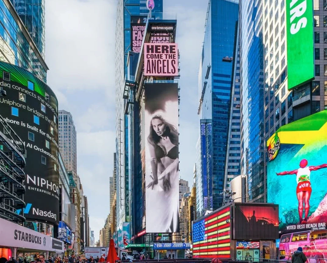 Anuncio vertical de Victoria’s Secret en Times Square con el texto Here Come the Angels.